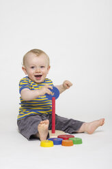 Porträt eines kleinen Jungen, der mit Spielzeug spielt, lächelnd - MUF001345