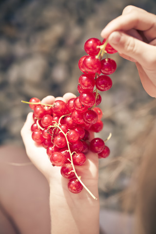 Deutschland, Bayern, Mädchen mit Strauß roter Johannisbeeren, lizenzfreies Stockfoto