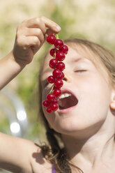 Germany, Bavaria, Girl eating red currants - SARF000094