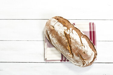Gebackenes Brot mit Serviette auf Holztisch, Nahaufnahme - MAEF007161
