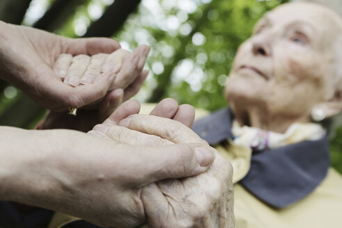 Deutschland, Nordrhein-Westfalen, Köln, Seniorin hält Hände einer reifen Frau, Nahaufnahme - JAT000196