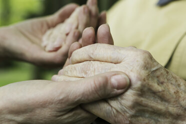 Germany, North Rhine Westphalia, Cologne, Senior woman holding hands of mature woman, close up - JAT000221
