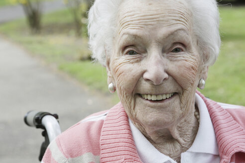 Deutschland, Nordrhein-Westfalen, Köln, Porträt einer älteren Frau im Rollstuhl sitzend, lächelnd - JAT000198