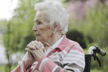 Germany, North Rhine Westphalia, Cologne, Senior woman sitting on wheelchair, looking away - JAT000178