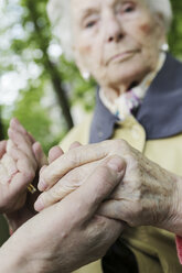 Deutschland, Nordrhein-Westfalen, Köln, Seniorin hält Hände einer reifen Frau, Nahaufnahme - JAT000201