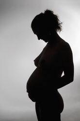 Silhouette einer nackten jungen schwangeren Frau, Studioaufnahme - BFRF000256
