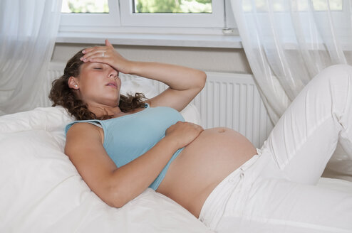 Deutschland, Brandenburg, junge schwangere Frau bekommt Kopfschmerzen - BFRF000265