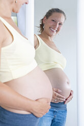 Deutschland, Brandenburg, junge schwangere Frau schaut in den Spiegel - BFRF000279