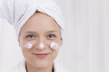 Portrait of young woman with cream on face, smiling - DRF000137