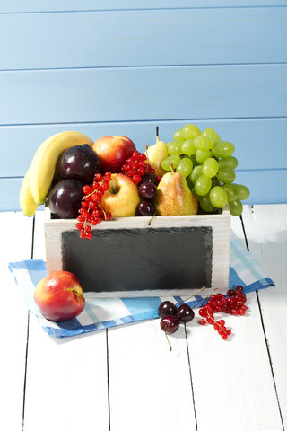Holzkiste mit verschiedenen frischen Früchten auf dem Tisch, Nahaufnahme, lizenzfreies Stockfoto