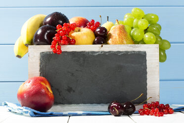 Wooden box with variety of fresh fruits on table, close up - MAEF007207