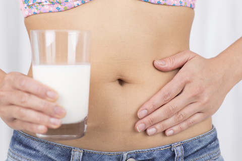 Mittlere erwachsene Frau hält ein Glas Milch, Nahaufnahme, lizenzfreies Stockfoto