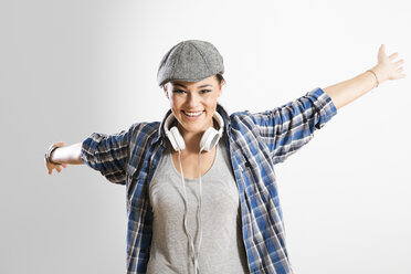 Portrait of young woman standing against white background, smiling - FKF000210