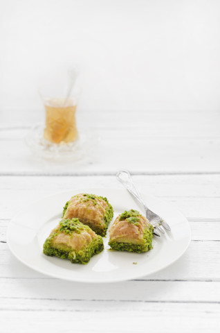 Plate of turkish baklava and glass of tea on wooden table, close up stock photo