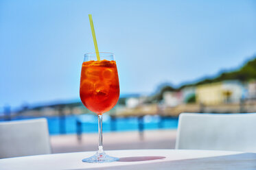 Italy, Glass of Aperol spritz drink at street cafe near beach - DIKF000068