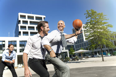 Group of businesspeople playing basketball outdoors - SU000027