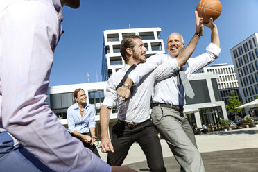 Gruppe von Geschäftsleuten spielt Basketball im Freien - SU000026