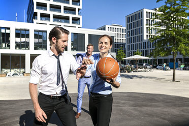 Group of businesspeople playing basketball outdoors - SU000025