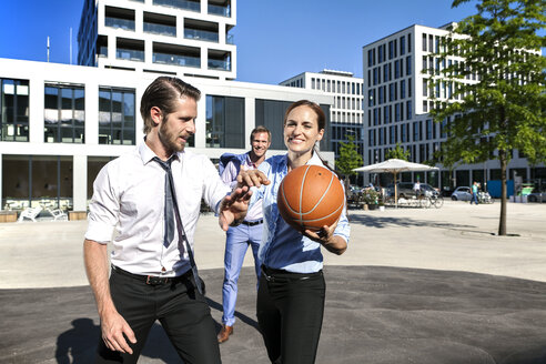 Gruppe von Geschäftsleuten spielt Basketball im Freien - SU000025
