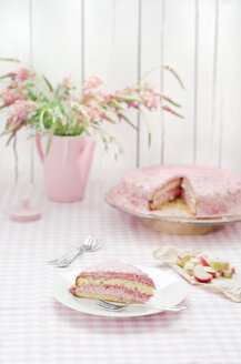 Rhubarb and raspberry cream cake with pink flowers on table, close up - CZF000042