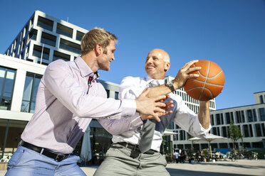 Zwei Geschäftsleute spielen Basketball im Freien - SU000055