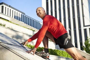 Mature athletic man stretching outdoors - SU000013