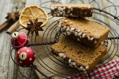 Gingerbread cake with christmas baubles and dried orange, spice on wooden table, close up - OD000321