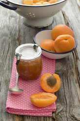 Aprikosenmarmelade mit einer Schale mit Aprikosen auf einem Holztisch, Nahaufnahme - OD000317