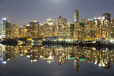 Kanada, Vancouver, Yachthafen mit Schiffen und Skyline bei Nacht, lizenzfreies Stockfoto