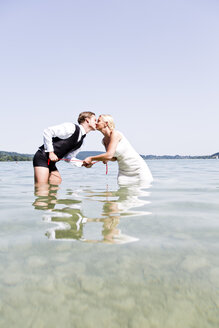 Deutschland, Bayern, Tegernsee, Hochzeitspaar im See stehend, küssend - RFF000088