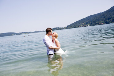 Deutschland, Bayern, Tegernsee, Hochzeitspaar im See stehend, küssend - RFF000091