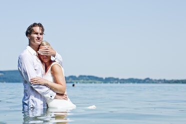 Deutschland, Bayern, Tegernsee, Hochzeitspaar im See stehend, Mann schützt die Augen der Frau - RFF000097