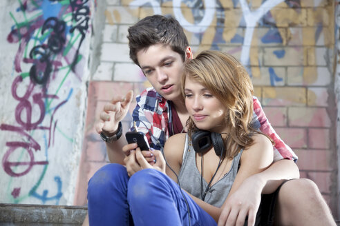 Germany, Berlin, Teenage couple on mobile phone - MVC000005