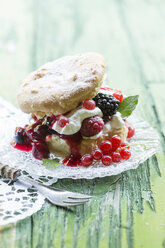 Puffs with cream and berries on green table, close up - STB000008