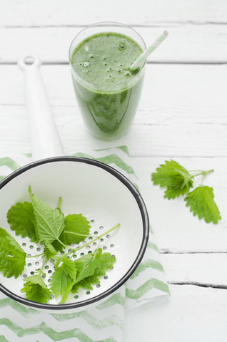 Glas grüner Smoothie mit Brennnessel im Sieb, Nahaufnahme, lizenzfreies Stockfoto