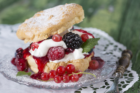 Puffs mit Sahne und Beeren auf Holztisch, Nahaufnahme, lizenzfreies Stockfoto