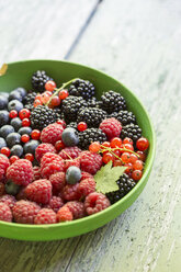 Bowl of berries on wooden table, close up - STB000024