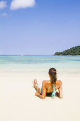 Thailand, Insel Koh Surin, Frau liegt am weißen Sandstrand - MBEF000721