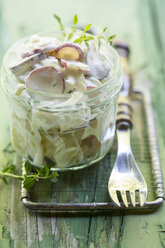 Germany, Potato salad with radish and thyme on wooden table - STB000033