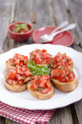 Bruschetta with tomatoe and basil on plate, close up - OD000354