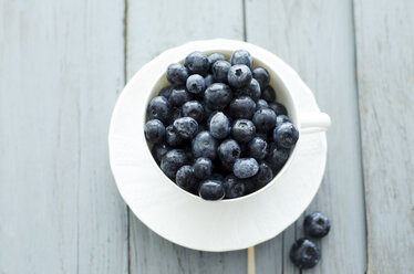 Cup of blueberries on wooden table, close up - ODF000361