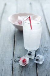 Glas Limonade mit Eiswürfeln und gefrorenen Beeren auf Holztisch, Nahaufnahme - OD000363