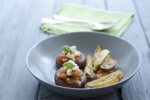 Schale mit Pilzen, Bratkartoffeln und Serviette auf Holztisch, Nahaufnahme - OD000378