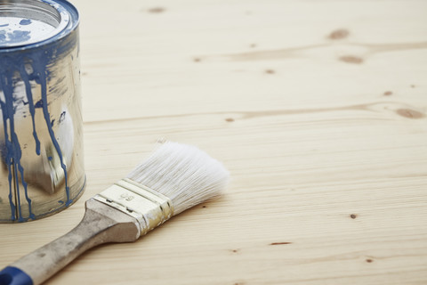 Paint tin and paintbrush on wood, close up stock photo