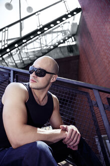 Man with bald head and sunglasses sitting outdoors - VTF000019