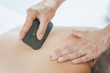 Traditional Chinese Medicine, TCM, female therapist during Gua Sha therapy - MJF000376