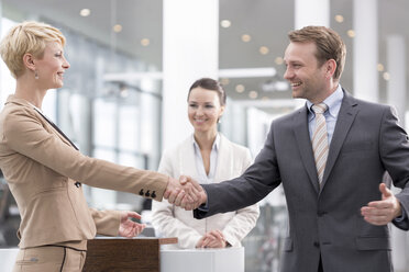 At the car dealer, Happy man and woman shaking hands - MLF000061