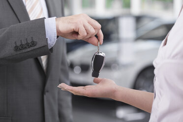 At the car dealer, Salesman handing over car key to client - MLF000034