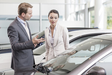 At the car dealer, Salesman showing new car to client - MLF000035