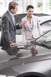 At the car dealer, Salesman showing new car to client - MLF000037